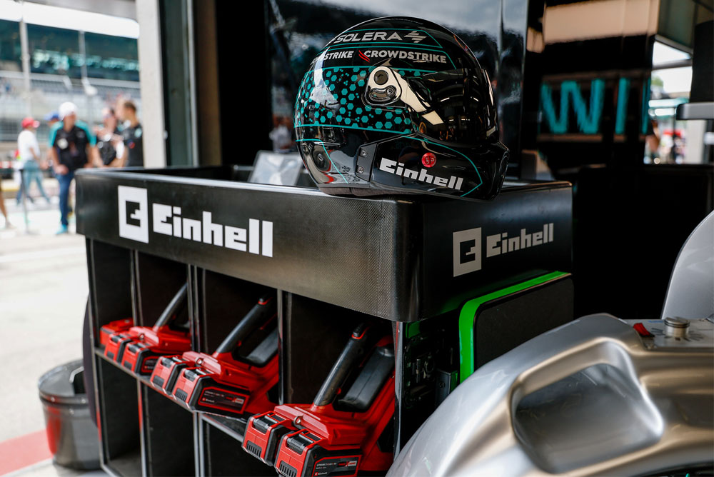 Herramientas inalámbricas Einhell en un carrito, con un casco de carreras encima.