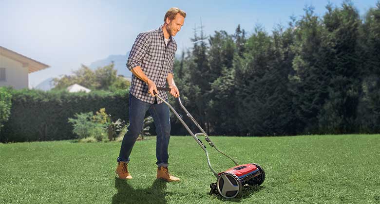 man with hand lawn mower