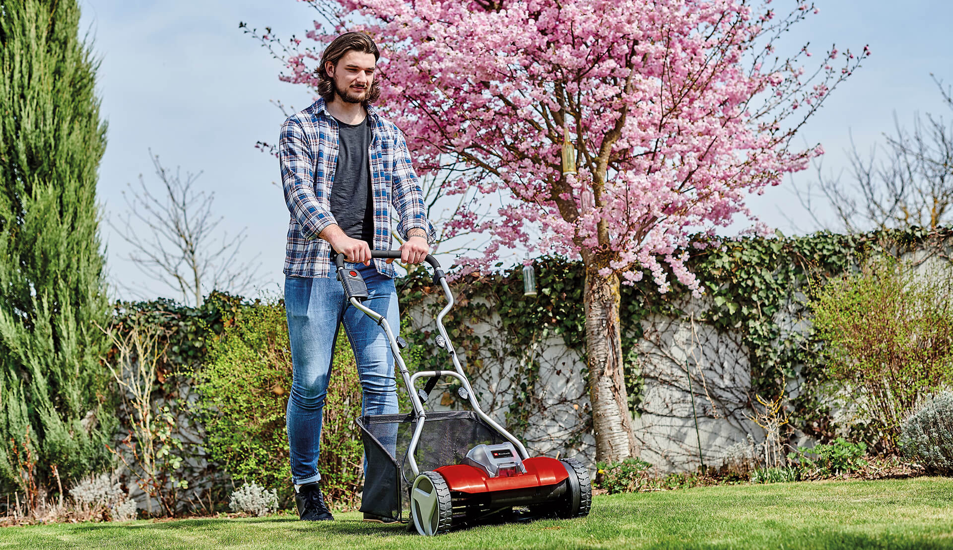 man mowing the lawn with a hand lawn mower