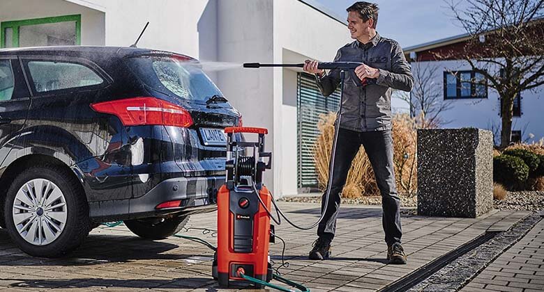 man cleaning the car with a high pressure cleaner