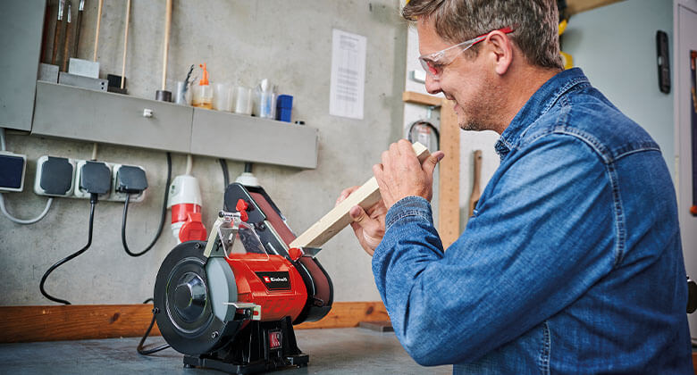 man using a stationary belt sander