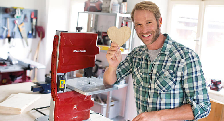 man with a band saw and a wooden heart